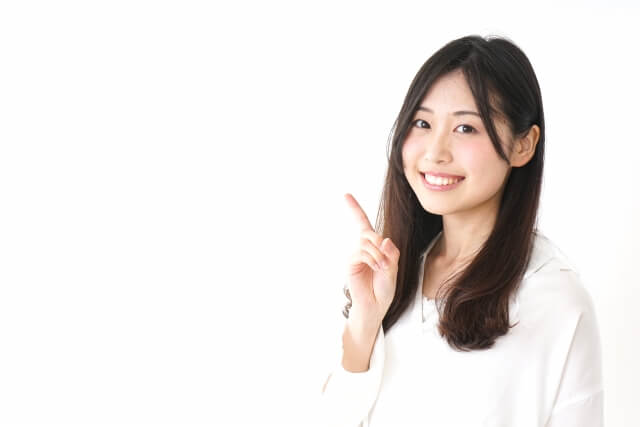 微笑む女性の指ピースサイン