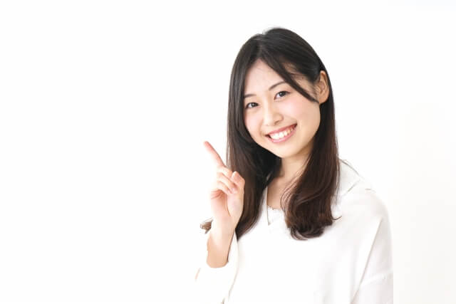 白い背景でピースサインする女性