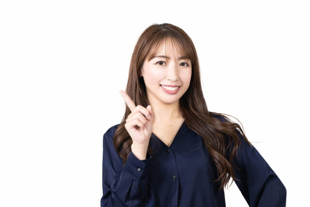 指を立てて笑顔で説明する女性